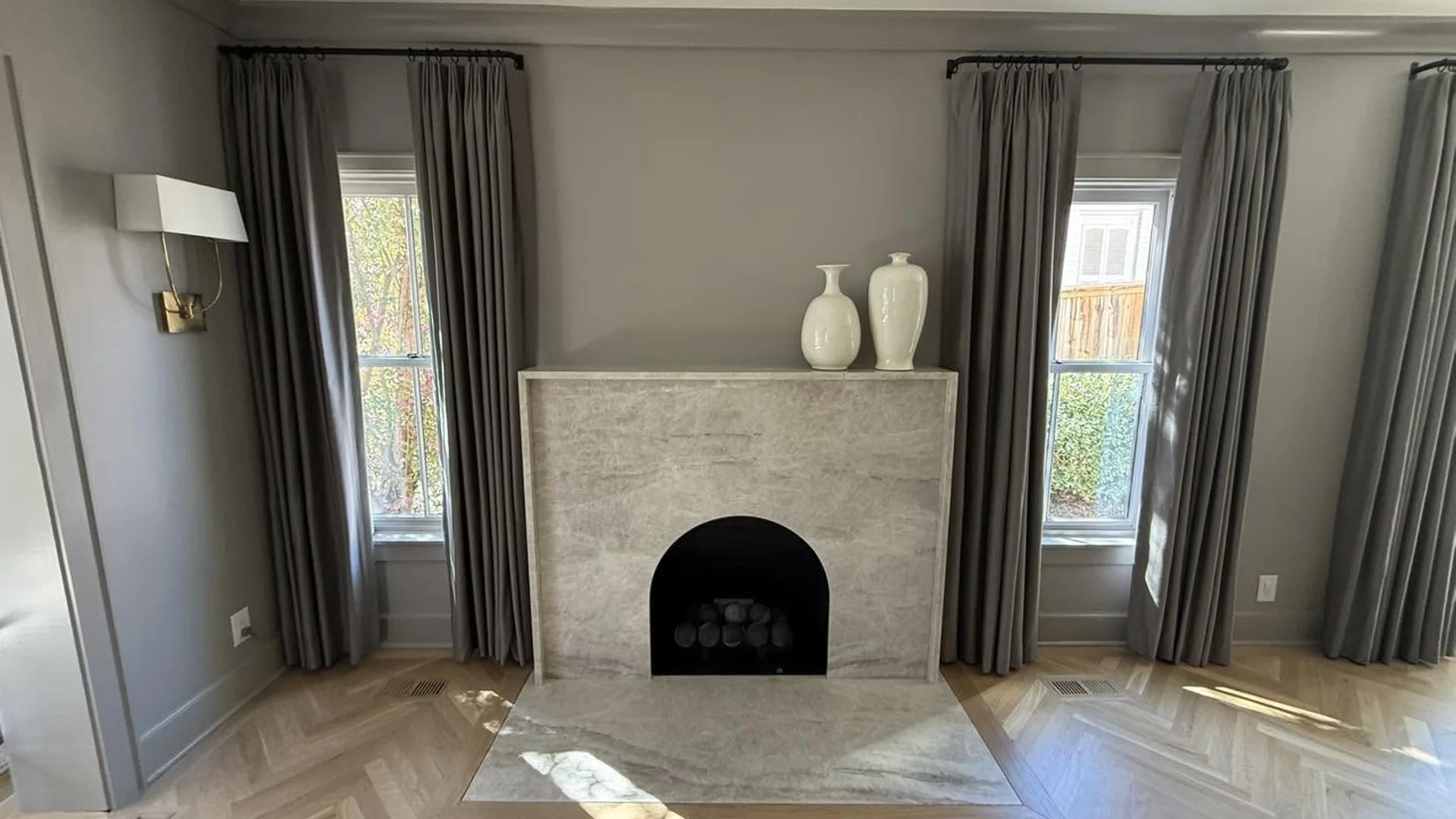 Stone fireplace surround and herringbone hardwood floor by North South Construction