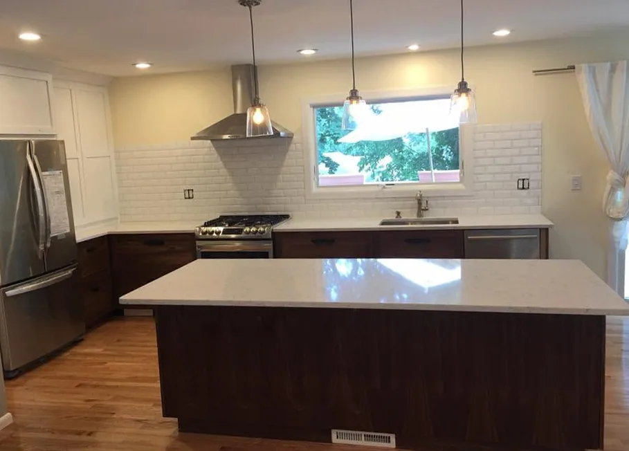 Renovated kitchen with quartz island and walnut cabinetry by North South Construction