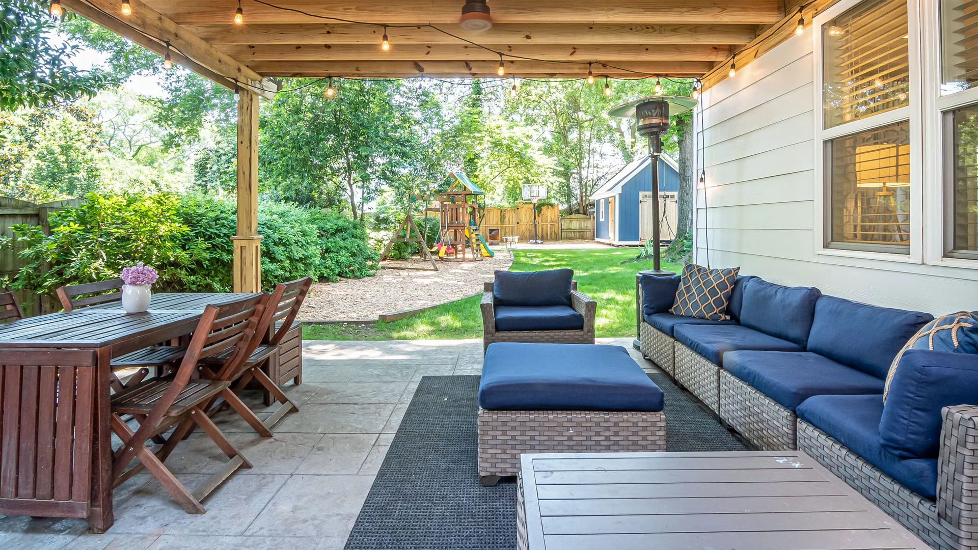 Covered patio with outdoor sectional, dining area, and string lights